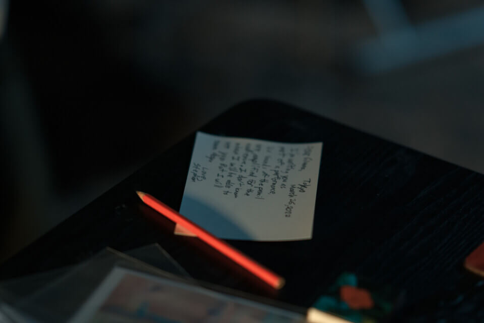 A postcard with writing on it and a pencil on a table