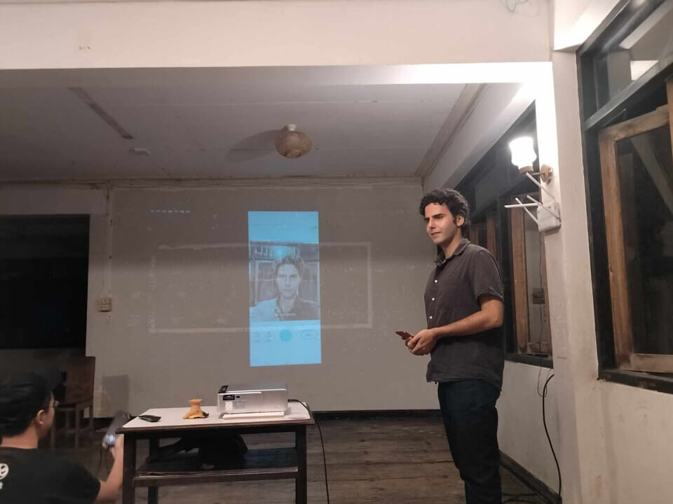 The performer holds his phone and looks at the audience.