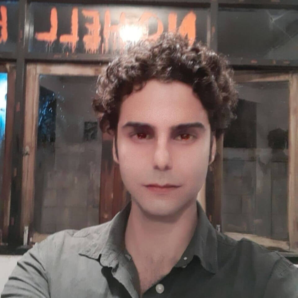 Photo of the performer, post-performances. His eyes are narrow and have a reddish hue. The area around his mouth is very smooth.