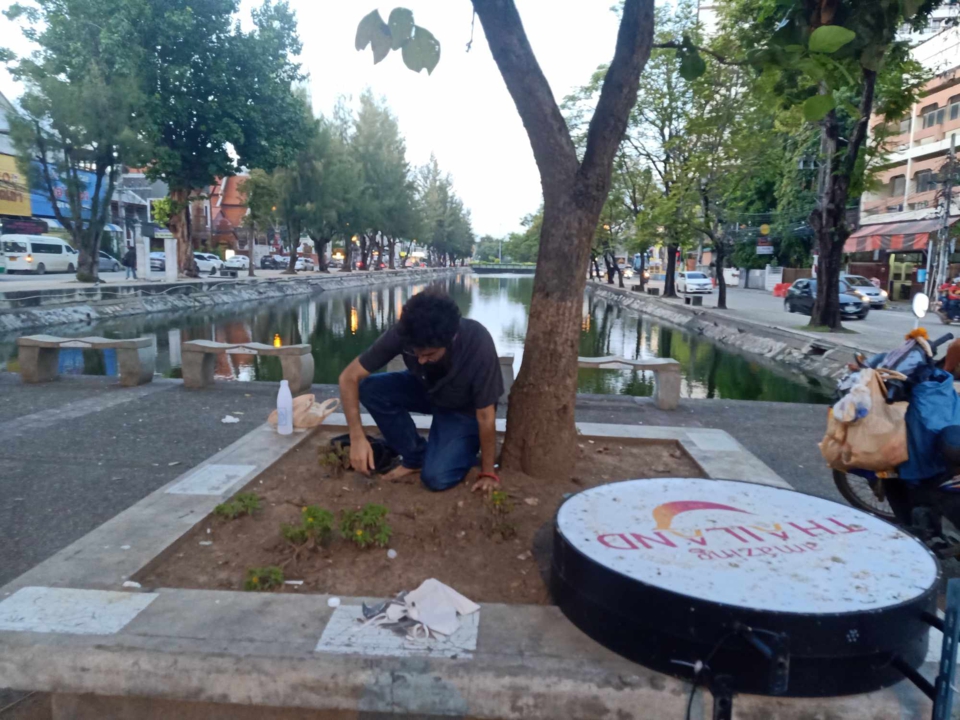 the artist, stephan e perez, smooths out the dirt, preparing it for construction
