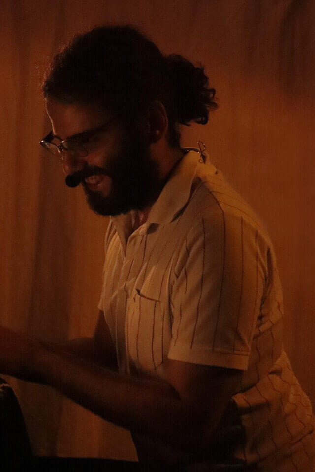 The performer leans forward and laughs