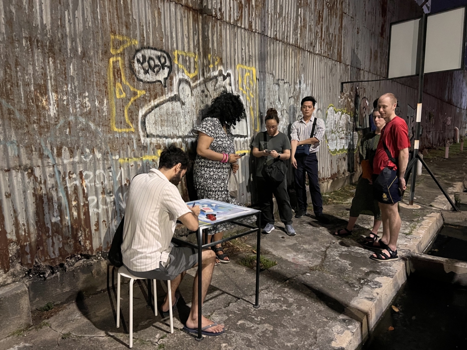 as the artist writes, about six members of the audience watch him from nearby