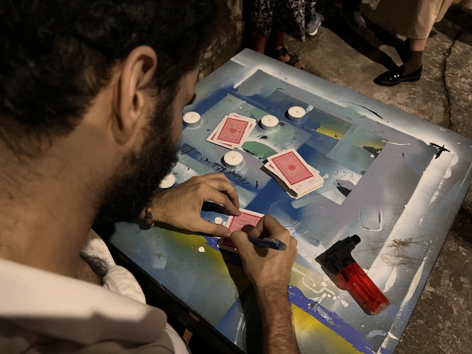 over-the-shoulder view of the artist writing on a card