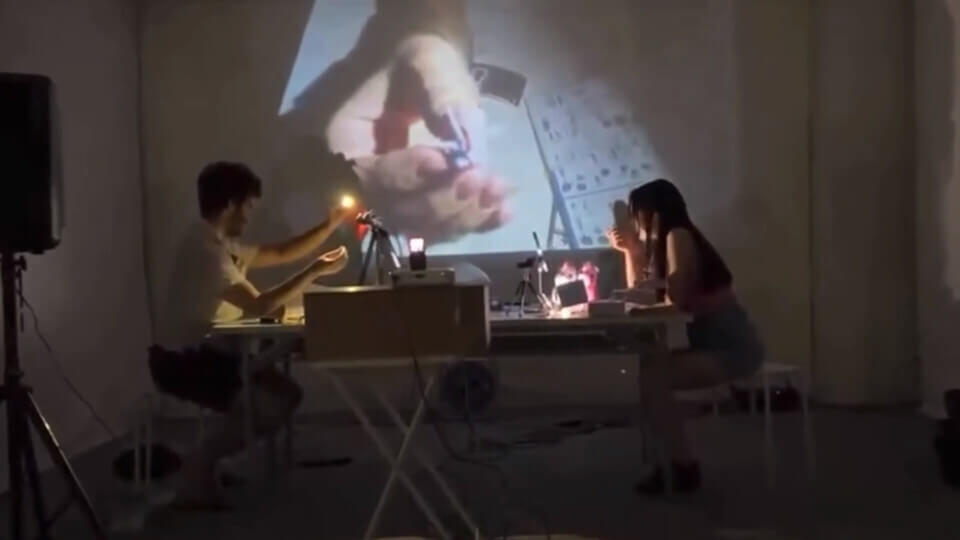 stephan holds up the completed gundam head to the camera, shown in the projection