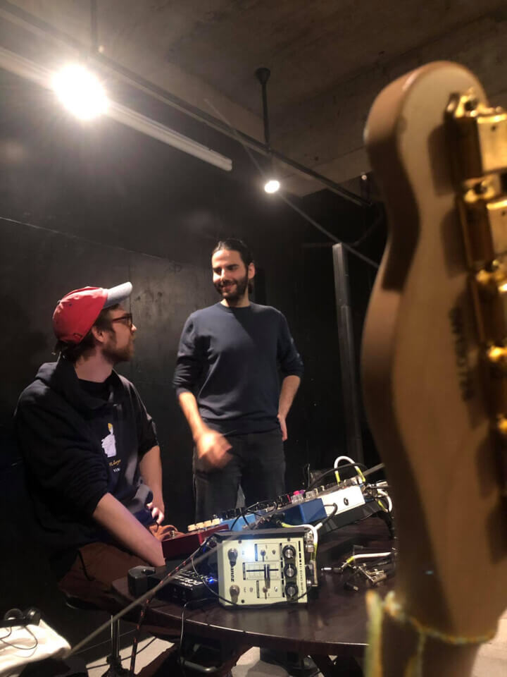 eric and stephan, in position for the performance, smile at each other