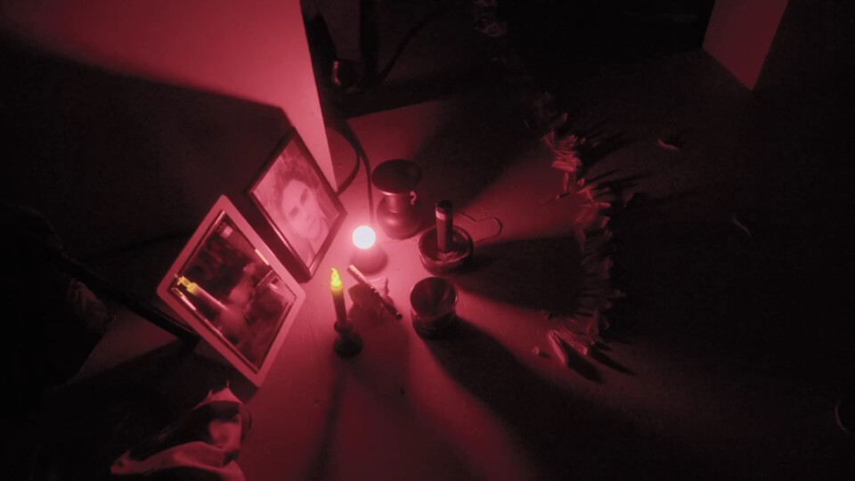 a shrine in red-lighting, erected for takeya daisuke's performance, features an odd picture of stephan e perez, as if honoring a departed loved one