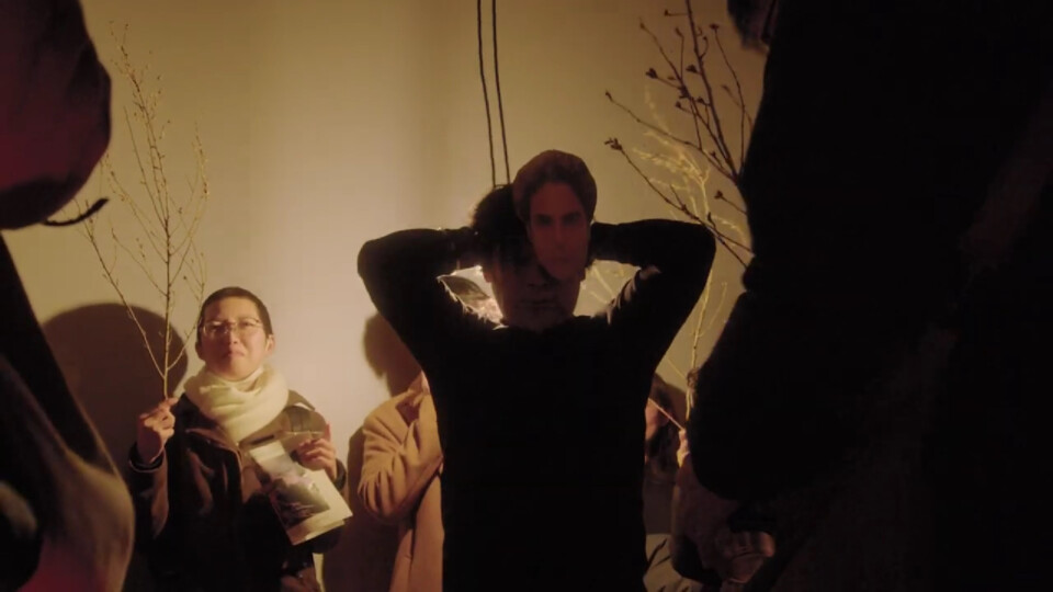 takeya daisuke dons a stephan mask, as the event guests hold tree branches around him